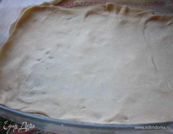 Тесто поделим на 12 частей. Каждую часть будем раскатывать тонко-тонко, до прозрачного состояния. 
Делайте это аккуратно, не торопясь, и все получится. 
Форму (у меня 27*14,можно взять круглую 26 см) смажем сливочным маслом. Положим первый раскатанный листок, смажем его сливочным маслом как следует и положим второй листок сверху.