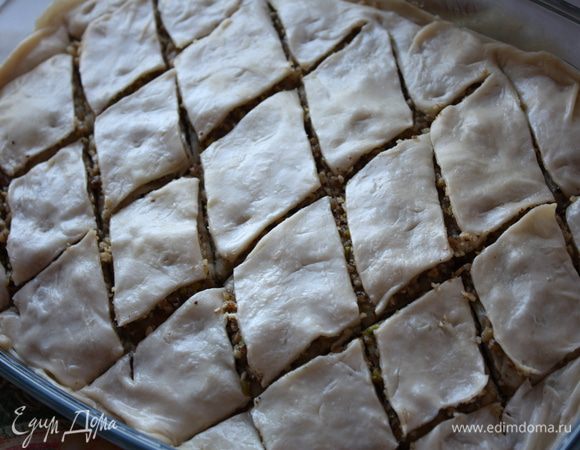 На последний слой начинки кладем листочек, смазываем его сливочным маслом и кладем еще один листочек. Сверху все смазываем сливочным малом и нарезаем пахлаву ромбами. После выпечки это будет очень трудно сделать.