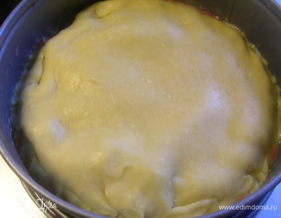 Тесто раскатываем размером немного больше диаметра формы и накрываем нашу начинку, подтыкая края. Ставим в духовку, разогретую до 180°C , выпекаем 20 минут до золотистого цвета.