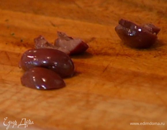 Оливки раздавить плоской стороной ножа, удалить косточки; половину оливок разрезать на несколько частей.