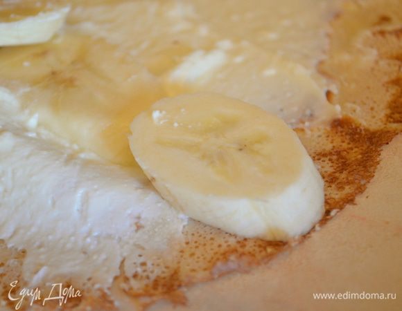 На край блина, который ближе к вам выложить дольки бананов и свернуть в тугой ролл. Нарезать на кусочки.