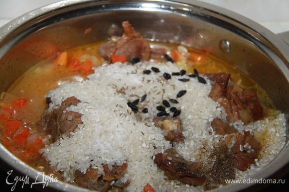 Когда мясо станет мягким, можно добавлять рис и специи.