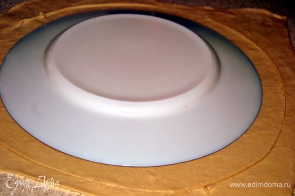Раскатать тесто и вырезать два круга. Один круг переложить на смоченный холодной водой противень.