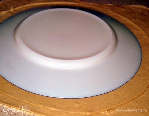 Раскатать тесто и вырезать два круга. Один круг переложить на смоченный холодной водой противень.