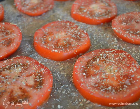 Выкладываем помидоры на застеленный пергаментом противень, солим, перчим, посыпаем травками, побрызгать половиной оливкового масла и запекать примерно 30 минут при 150 градусах. 