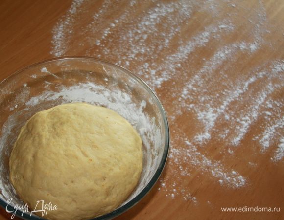 Тесто увеличилось, можно начинать раскатывать его. Присыпать стол мукой.