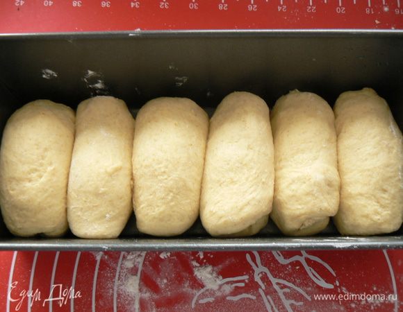 Подошедшее тесто разделить на 7-8 частей. Сформировать в "пальчики" длиной соответствующей ширине формы для выпечки, выложить их один к другому в форму.