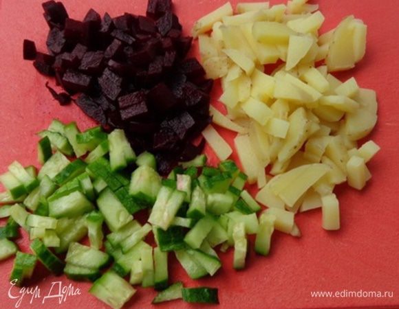 Нарезать мелкими кубиками огурцы, свеклу и картошку, положить в кастрюлю, перемешать.