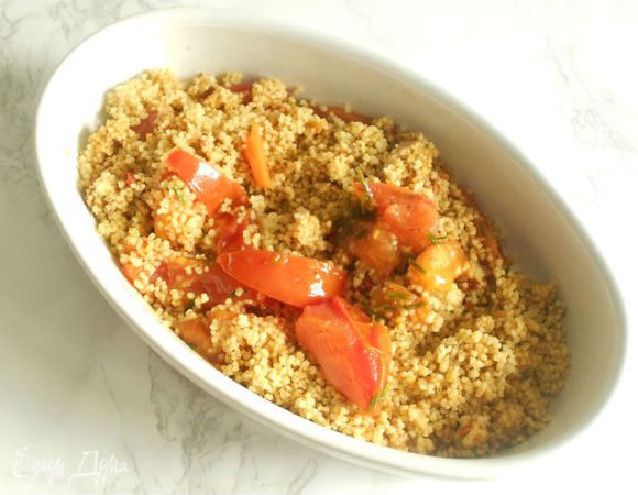 
Кускус разрыхлить вилкой и добавить 1 ст.л. оливкового масла.
Помидоры с луком и кускус переложить в форму для запекания, добавить 200 мл овощного бульона.