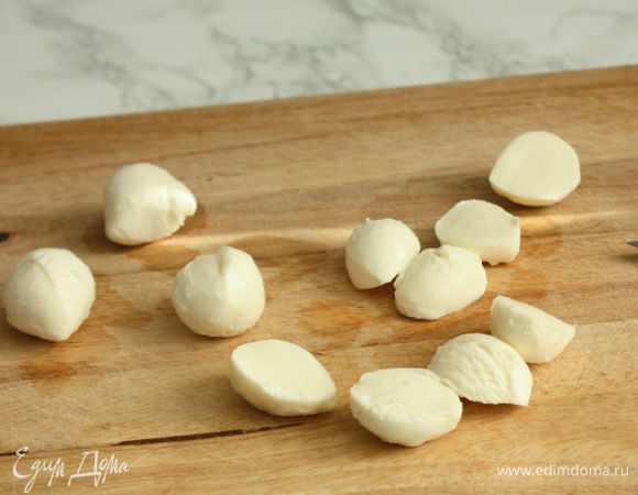   Моцареллу нарезать.За 5 мин до окончания запекания на томаты выложить кусочки моцареллы и положить "крышечки",продолжить запекать.