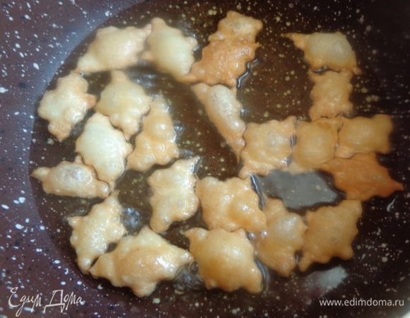 В небольшую глубокую емкость налить растительное масло, как для жарки во фритюре. Раскалить его на среднем огне и по частям обжарить печенье до приятного золотистого цвета.