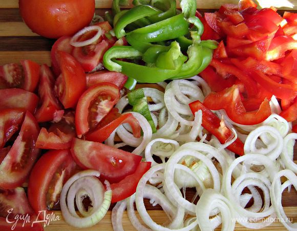 Репчатый лук очистить, нарезать кольцами. Перцы очистить от семян и нарезать соломкой. 3 помидорки нарезать дольками, а 2 другие нарезать кружочками.
