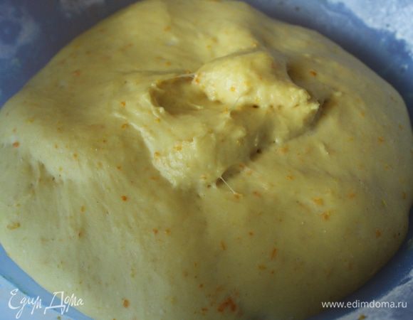 Замесить тесто. Перемешать муку с дрожжами, добавить размягченное сливочное масло, соль и сахар, затем добавить яйца и молоко. Хорошо вымесить тесто до эластичности. Добавить цедру и тщательно ее вмешать в тесто. Сформировать из теста шар, поместить в чашку, накрыть полотенцем и оставить на 1 час. Тесто должно увеличиться в два раза.