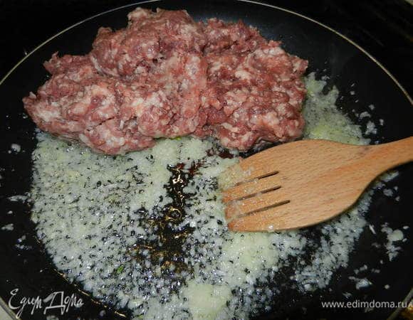Измельчить лук с чесноком и пассировать на растительном масле. Добавить фарш и все обжарить.