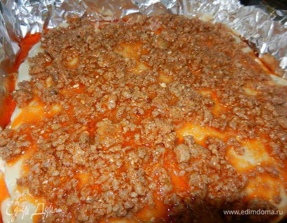  Тесто делим на 6 частей и раскатываем в тонкий пласт. Выкладываем в форму пласт теста, а на него выкладываем начинку и поливаем белым соусом.