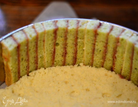 Выложить одну половинку бисквита в разъемную  форму и по кругу выкладывать полоски, очень плотно! прижимая  друг к другу, соединяя их клубничным джемом.