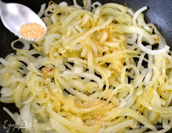 Затем снять крышку, увеличить огонь. Добавить сахар (я всегда использую коричневый тростниковый сахар) и тщательно размешать, позволив сахару раствориться, а луку приобрести характерный коричневатый оттенок. 