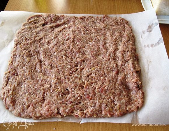 На лист пергамент выкладываем фарш и руками разделываем его в виде листа толщиной около 1,5 см.