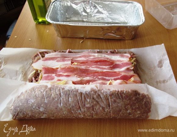 Аккуратно с помощью листа бумаги начинаем сворачивать все это в рулет.