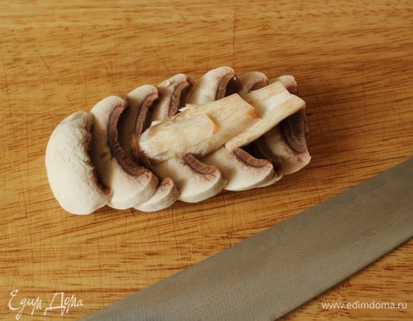 Шампиньоны почистить и нарезать тонкими пластинками. Слегка обжарить с обеих сторон.