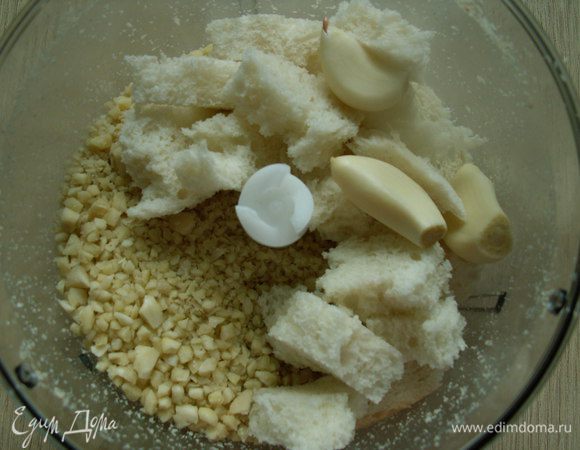  Холодную воду ставим в морозильную камеру. В чашу блендера кладем миндаль ( я очищала миндаль заранее: миндаль бросаем в кипящую воду и варим 3 минуты, откидываем на дуршлаг и очищаем - это очень быстро! миндаль подсушиваем и используем), хлеб, чеснок  и перемалываем.