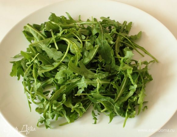 На плоском блюде сделать подушку из руколы.