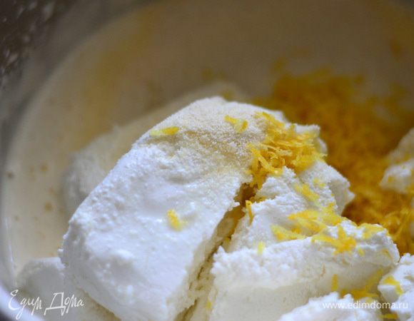 Взбить на высокой скорости миксера яйца с сахаром добела и кремообразного состояния. Добавить ко взбитым яйцам творог, цедру лимона, манную крупу, ваниль.