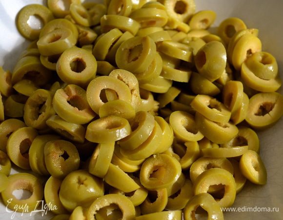 Нарезать оливки.