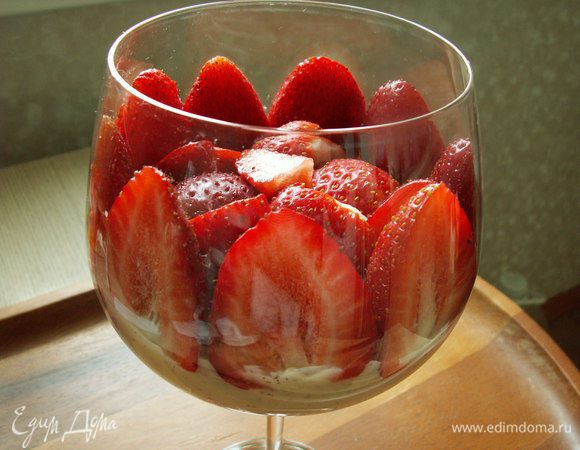 Следующим слоем выкладываем ревень. На ревень выкладываем заварной крем. Следующим слоем идет клубника. По кругу выкладываем половинки клубники, а в центр резаную.