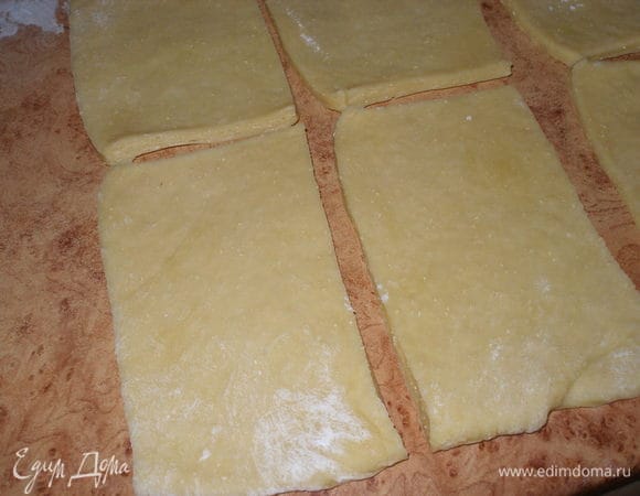 Тесто слегка обмять и вымесить с 1 ст.ложкой муки (+..-) муки. Положить на слегка посыпанную мукой рабочую поверхность и раскатать в прямоугольный пласт. Разрезать прямоугольник на равные полосы, затем на квадраты. Каждый квадрат смазать растопленным маслом.
