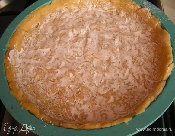 Тесто распределить по форме (у меня 20 см в диаметре) и наколоть, посыпать крахмалом,  чтобы во время выпечки жидкость из начинки не "разрушила" основу