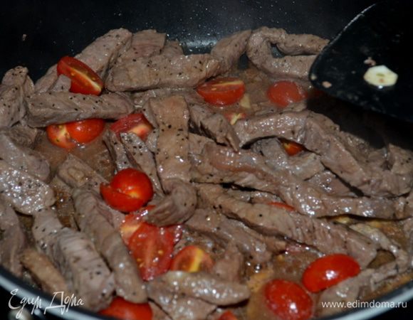 На горячую сковороду с растит.маслом также выложить говядину и обжаривать до готовности или до средней прожарки. Вернем перцы с луком, выложим томаты черри, зелень,соевый соус, кунжутное масло. Все перемешаем 1 мин. 