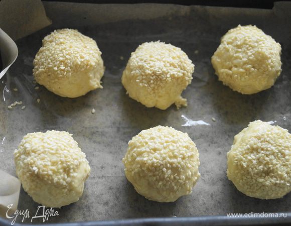 Сформировать из теста шарики, обмакнуть в яйцо и посыпать кунжутом. Выложить их на противень, застеленный бумагой для выпечки и смазанный маслом. Поставить в разогретую до 180 градусов духовку на 20-25 минут.