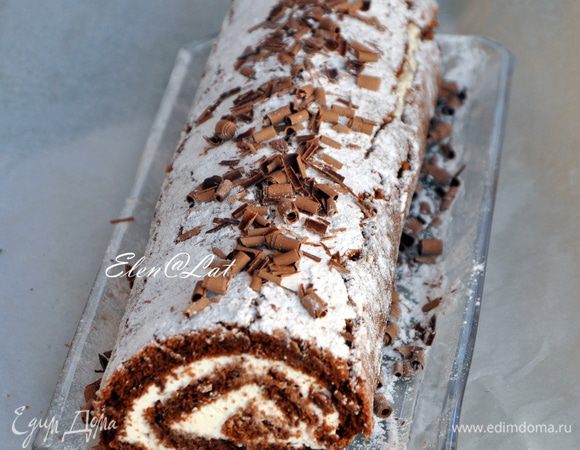 Дайте постоять рулету в холодильнике. Затем поверхность рулета присыпьте сахарной пудрой и украсьте шоколадной стружкой.
