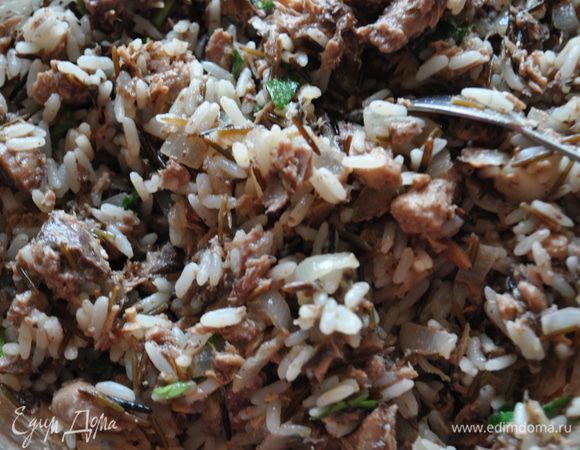 Рис отварить согласно инструкции на упаковке.

На оливковом масле обжарить мелко порезанный лук.

Тунец размять вилкой вместе с небольшим количеством жидкости.

Добавить к обжаренному луку тунец, вареный рис, посолить и поперчить по вкусу, перемешать.