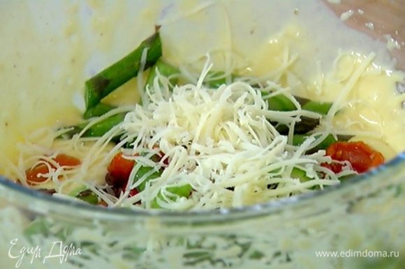 В тесто добавить оливки, вяленые помидоры, кусочки спаржи и половину натертого сыра, все перемешать.