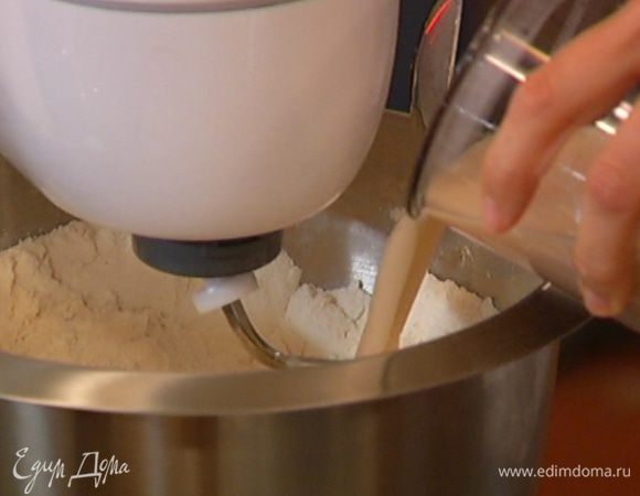 Муку и морскую соль всыпать в чашу комбайна и, перемешивая насадкой для теста, влить дрожжи. 