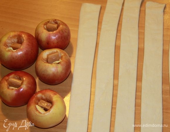 Подготовить яблоки: вымыть, удалить сердцевину, но не прорезая дно. Внутрь каждого яблока кладём кусочек масла и ириску (у меня "Кис-кис"). Тесто нарезаем на полоски.