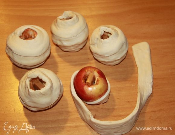 Оборачиваем полоску вокруг яблока. Обмазать тесто яйцом (или желтком).