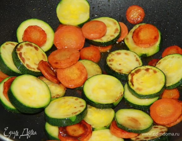Морковь и цукини нарезать кружочками толщиной около 1 см. В течение 10 минут обжарить на оливковом масле морковь, затем добавить цукини и готовить еще 5 минут.