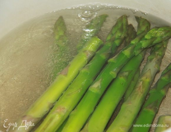 Подрезать кончики стеблей спаржи и отварить в течение 5 минут в кипящей подсоленной воде. Спаржу добавить к овощам и перемешать.