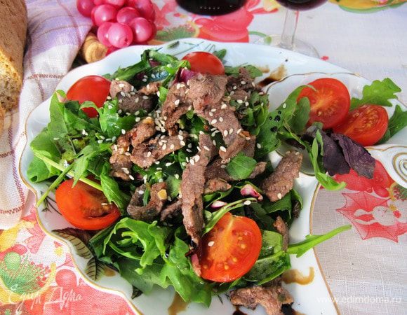 Сервируйте салат порционно. Выложите салатные листья, сверху — мясо и помидоры черри. Полейте мясным соком, выделившимся при обжаривании, сбрызните бальзамиком и посыпьте кунжутом.