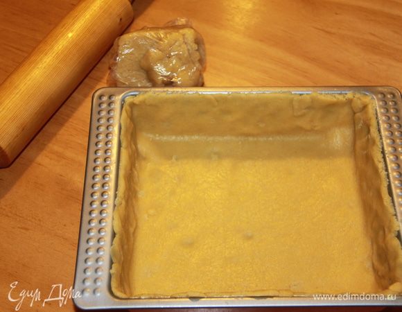 Тесто поделить на две неравные части. БОльшую часть раскатать и уложить в форму. На тесто рекомендуется положить бумагу и фасоль, я обошлась без них. 