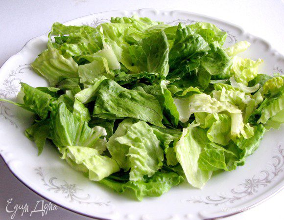 В тарелку выложите салатные листья.