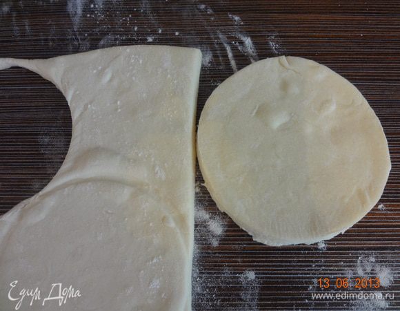 Тесто разморозить, выложить на присыпанную мукой поверхность и вырезать формочкой два круга диаметром 10-12 см. Переложить на противень, сбрызнутый водой.
