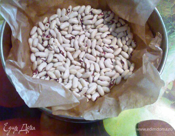 Достаём тесто из холода и распределяем по форме,выстланой пергаментом.
Сверху теста положим пергамент и засыпем фасолью, чтобы тесто не поднималось.Выпекаем в разогретой до 220° духовке ~20-25 минут (но вы ориентируйтесь по своей духовке, до получения светло-коричневого цвета).