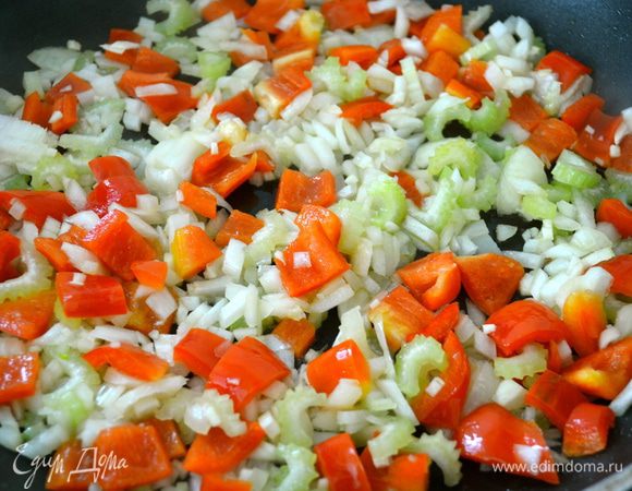 Добавить 2 ст.л. оливкового масла в сковороду и, помешивая, обжаривать лук, чеснок, сельдерей, красный перец, душицу и базилик 3 минуты.   