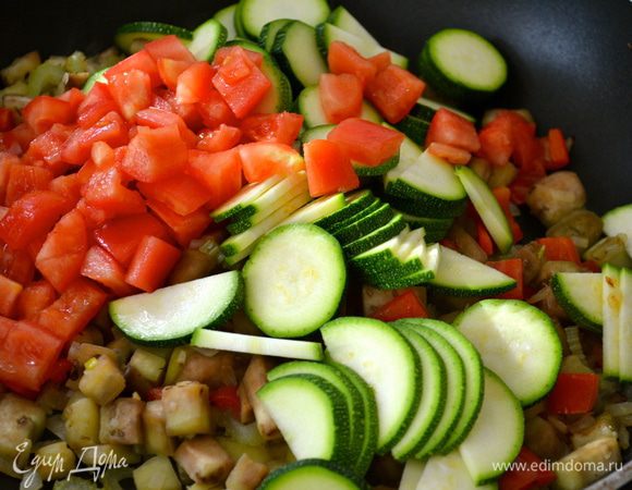Затем выложить также заранее подготовленные цуккини и помидоры на сковороду. 