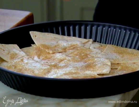 Кусочки тортильи выложить в форму для выпечки, полить сливками, посыпать сахаром и отправить в разогретую духовку на 7–10 минут.