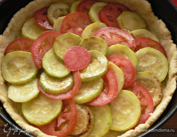 На тесто выкладываем кабачок, тонко порезанные помидоры